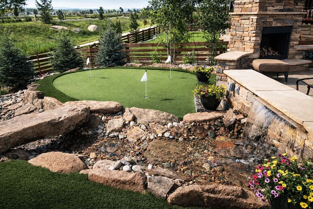 Backyard putting green beside a custom water feature